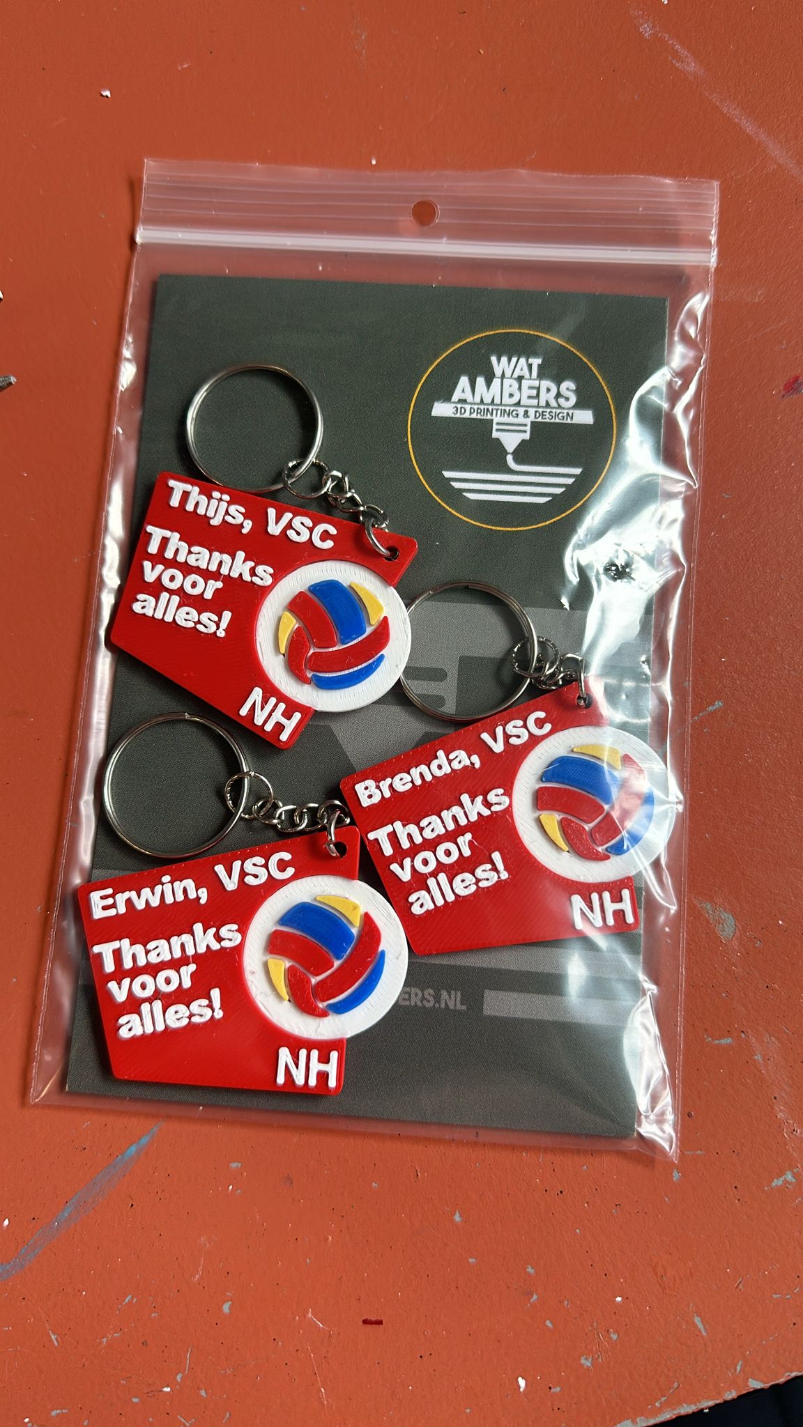 Een afbeelding van een verzameling kleurrijke 3D-geprinte VSC logo sleutelhangers, elk gepersonaliseerd met verschillende namen en ontwerpen, die perfect zijn om een persoonlijk tintje aan je sleutelbos te geven.