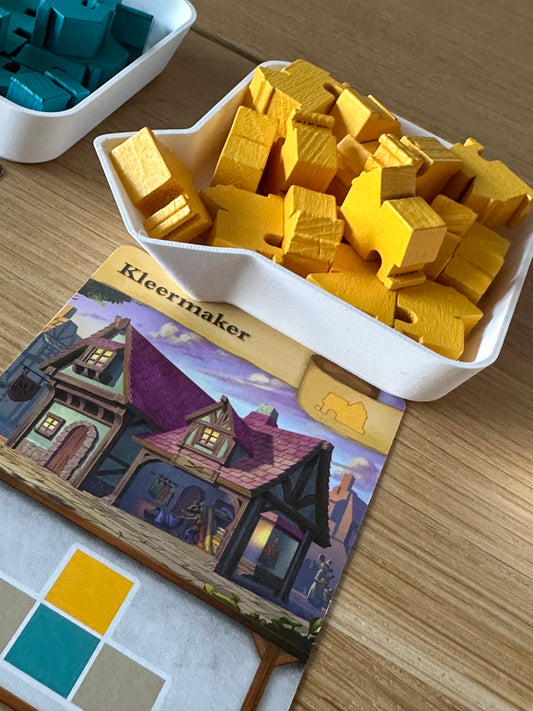 Een 3D-geprinte token tray met tuitje, gevuld met bordspel-tokens, klaar om in een zakje gegoten te worden.