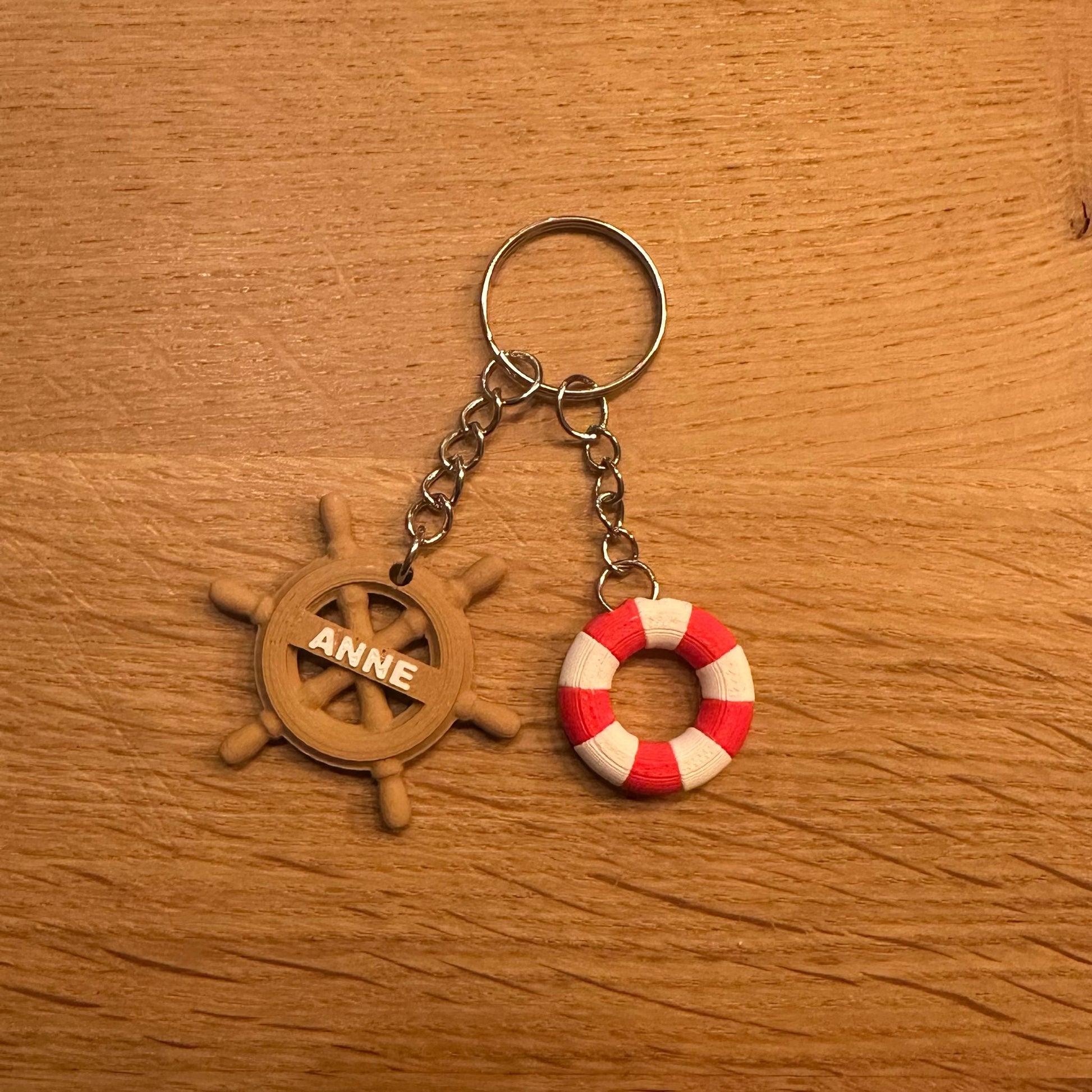Rood-witte boei en houten stuur sleutelhanger, personaliseerbaar met naam, perfect voor maritieme liefhebbers.